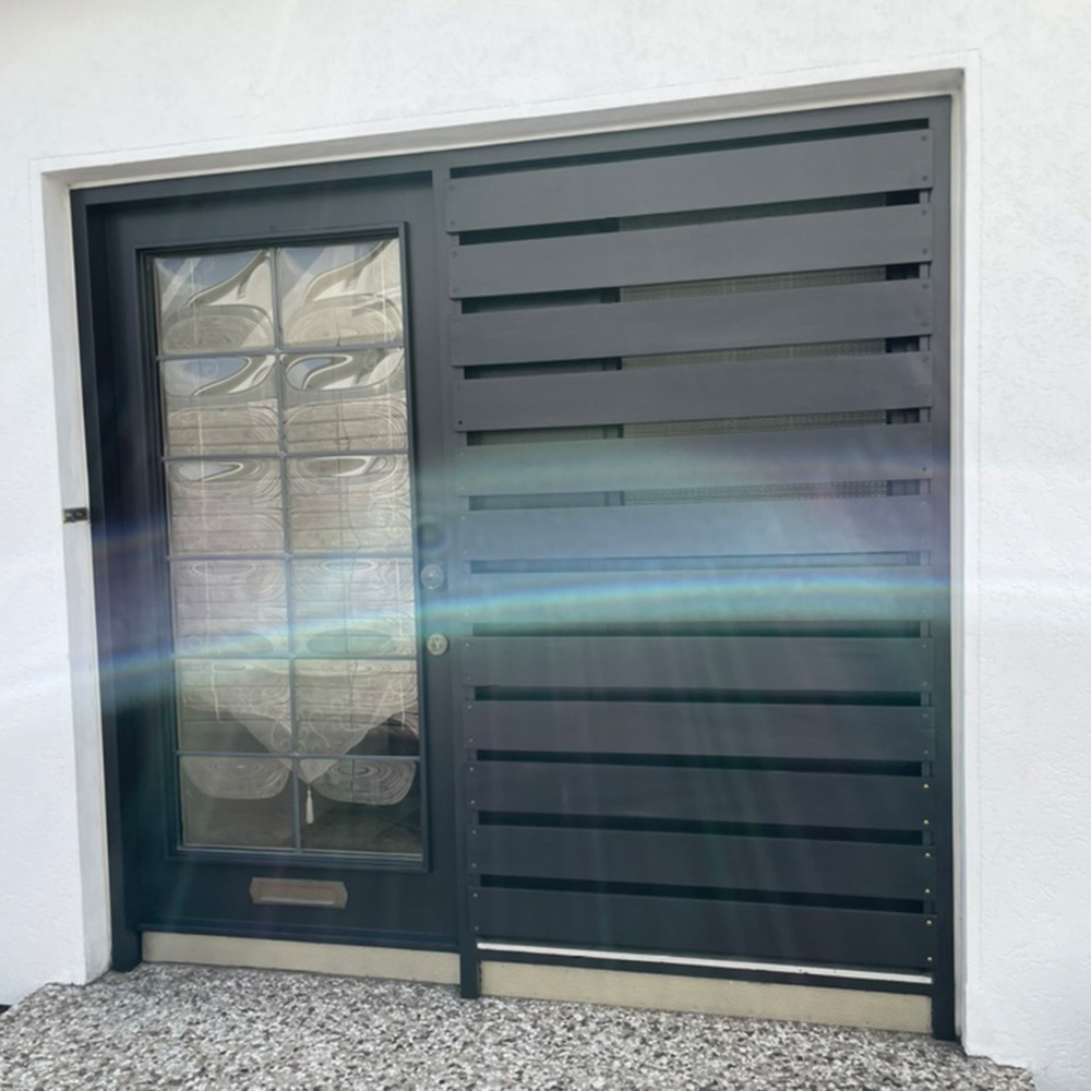 Eine moderne, schwarze Tür mit Glas und horizontalen Paneelen. Lichteffekt im Vordergrund.