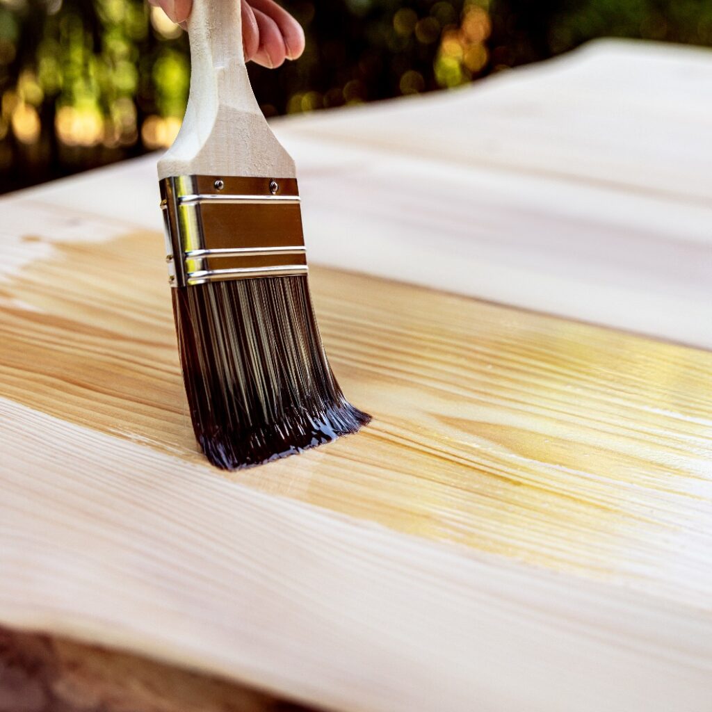 Lasieren eines Holztisches mit einem Haarpinsel und Öl